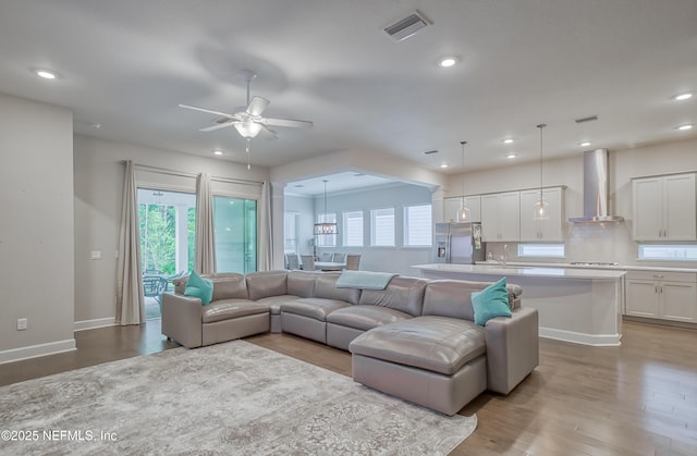 living room with ceiling fan and light hardwood / wood-style flooring