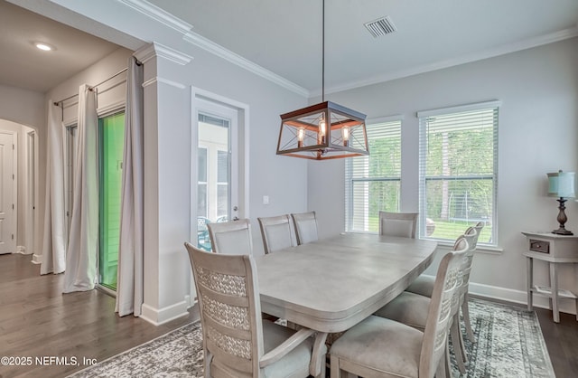 dining area featuring dark hardwood / wood-style flooring, a notable chandelier, and ornamental molding