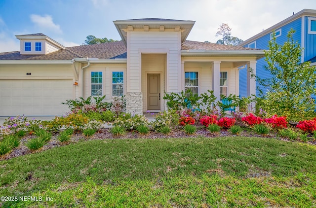 view of front of home with a garage and a front lawn