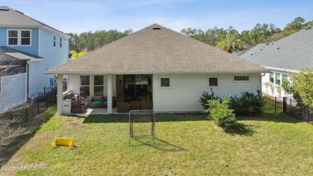 rear view of house with a patio and a lawn