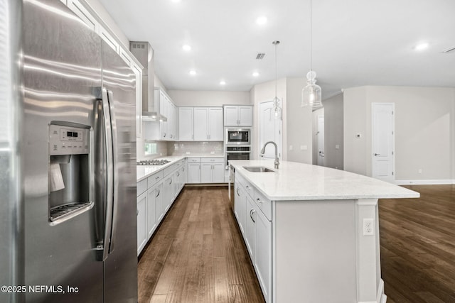 kitchen featuring wall chimney exhaust hood, a sink, dark wood finished floors, white cabinetry, and appliances with stainless steel finishes