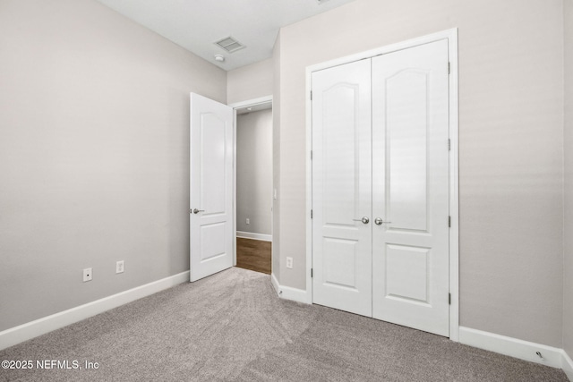 unfurnished bedroom with baseboards, carpet flooring, visible vents, and a closet