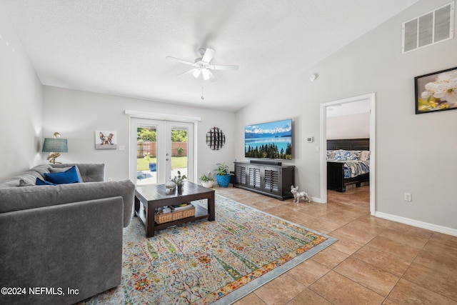 living room with french doors, tile patterned floors, lofted ceiling, and a textured ceiling