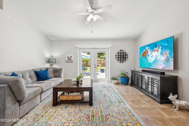 living room with french doors, ceiling fan, and a textured ceiling