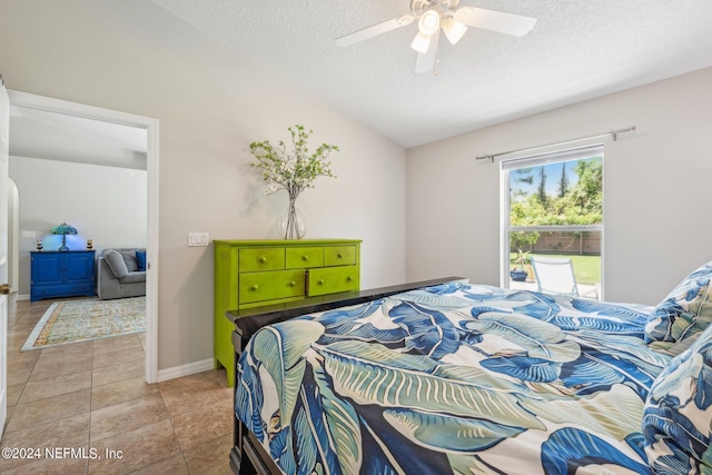 tiled bedroom featuring ceiling fan, lofted ceiling, and a textured ceiling