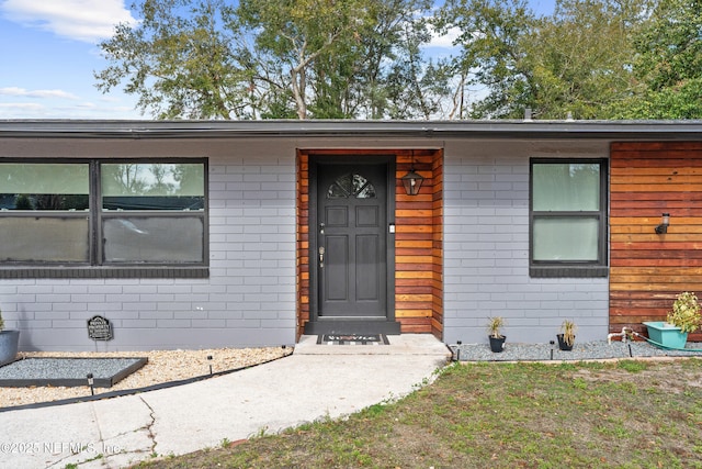 view of exterior entry with a yard