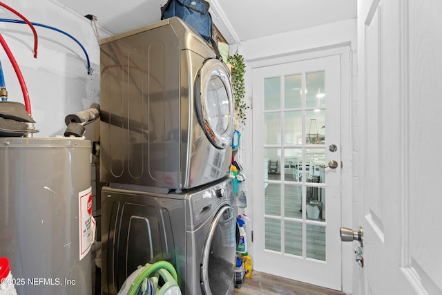 laundry room featuring stacked washer and dryer, wood-type flooring, and water heater