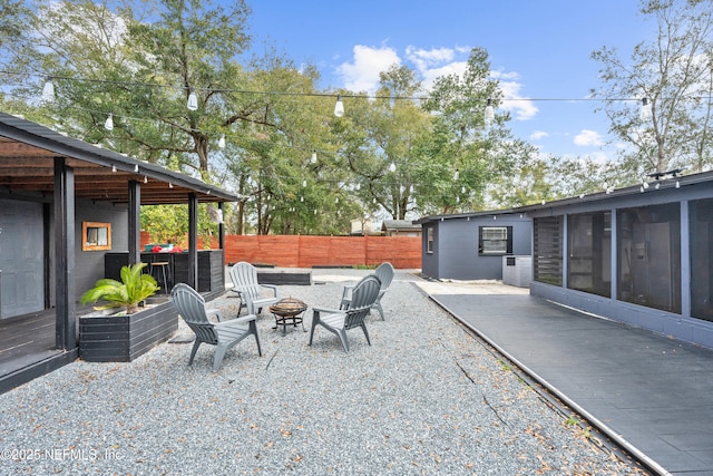 view of patio / terrace with an outdoor fire pit and a sunroom