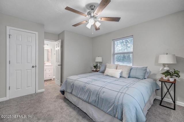 bedroom featuring ceiling fan, light colored carpet, and connected bathroom