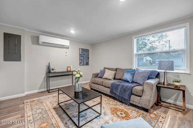 living room with ornamental molding, a wall mounted air conditioner, electric panel, and light wood-type flooring