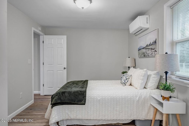 bedroom featuring wood-type flooring and a wall unit AC