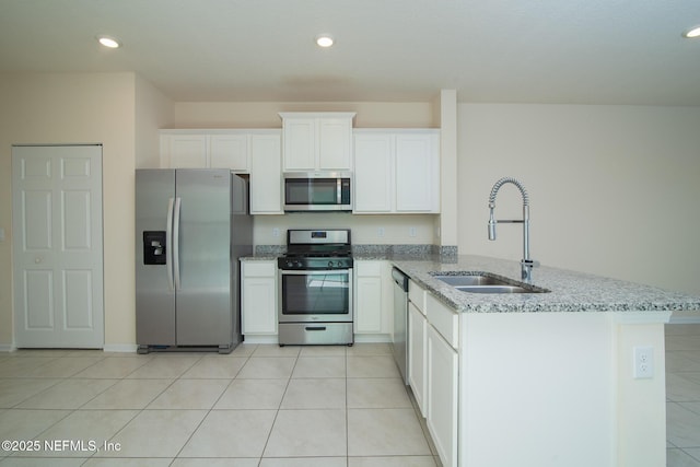 kitchen featuring light tile patterned flooring, sink, white cabinetry, appliances with stainless steel finishes, and light stone countertops