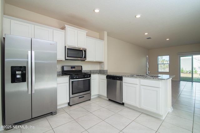 kitchen with white cabinetry, appliances with stainless steel finishes, kitchen peninsula, and sink