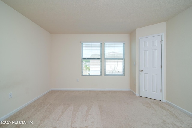 carpeted empty room with a textured ceiling