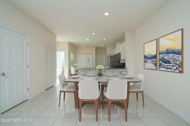 tiled dining room featuring sink