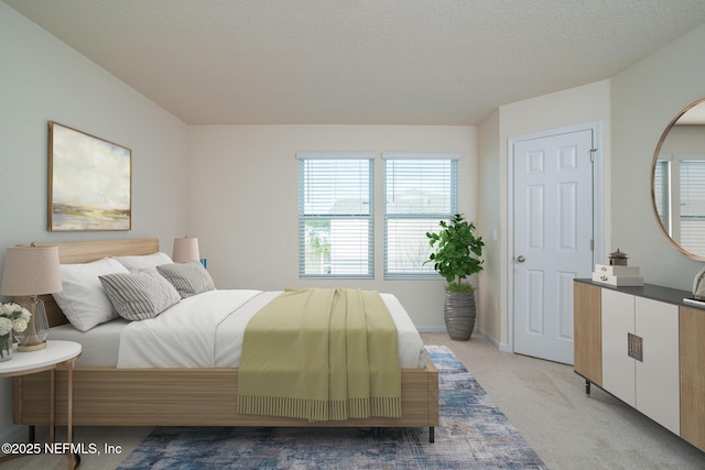 bedroom featuring light carpet and a textured ceiling