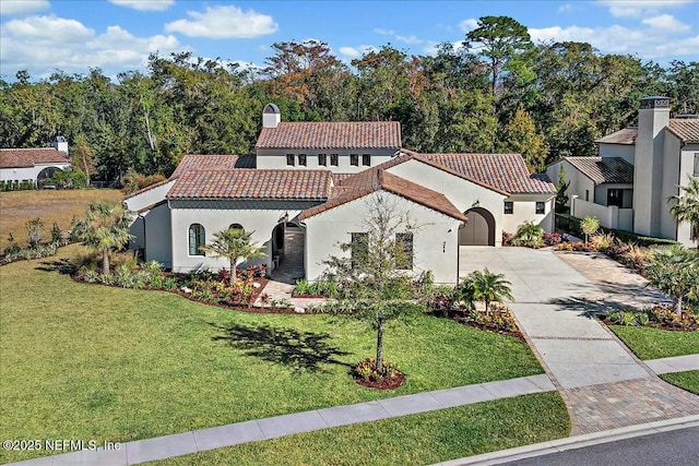 mediterranean / spanish house featuring a garage and a front lawn