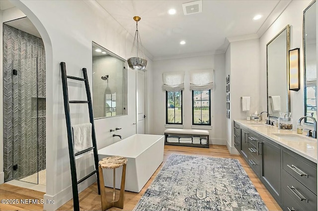 bathroom featuring crown molding, vanity, independent shower and bath, and hardwood / wood-style floors