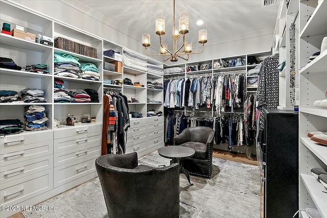 walk in closet with a chandelier