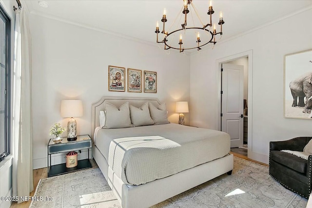 bedroom with crown molding, an inviting chandelier, and light hardwood / wood-style floors