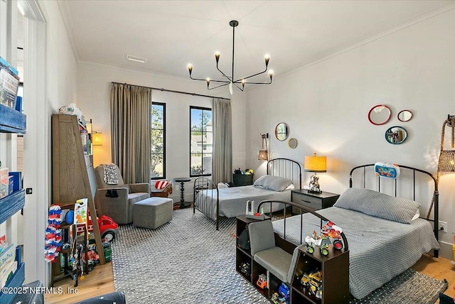 bedroom with an inviting chandelier, ornamental molding, and light hardwood / wood-style floors