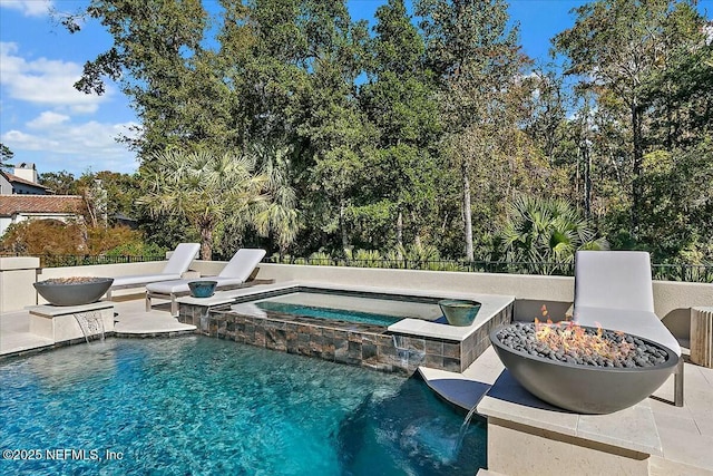 view of pool featuring an in ground hot tub, pool water feature, a patio, and an outdoor fire pit