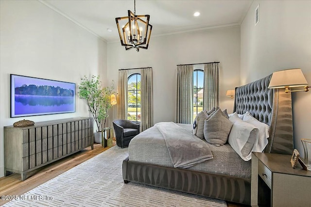 bedroom featuring crown molding, hardwood / wood-style floors, and an inviting chandelier