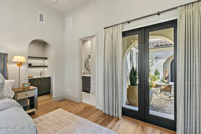 bedroom featuring crown molding, access to outside, french doors, and light wood-type flooring