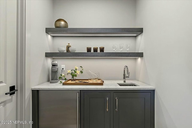 bar with gray cabinets and sink