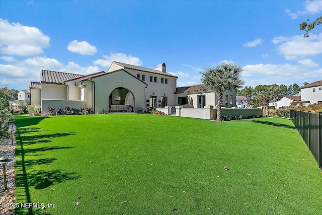 rear view of house featuring a yard