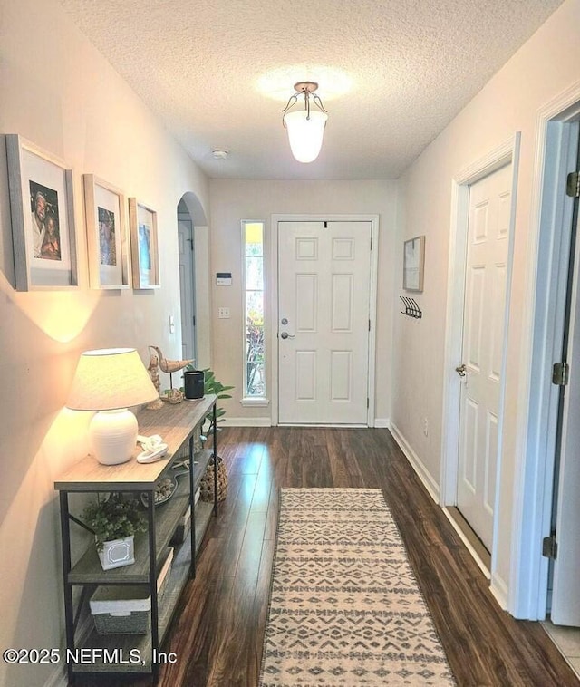 foyer with dark hardwood / wood-style floors and a textured ceiling