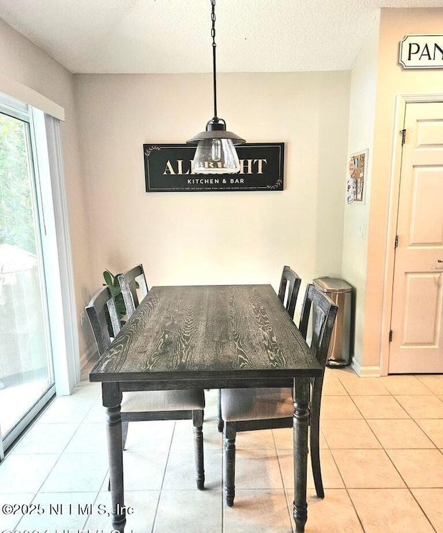 dining room with light tile patterned flooring and a textured ceiling