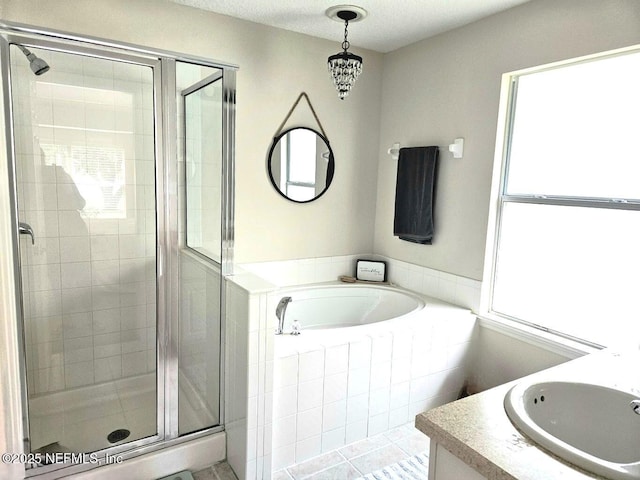 bathroom with vanity, shower with separate bathtub, and a textured ceiling