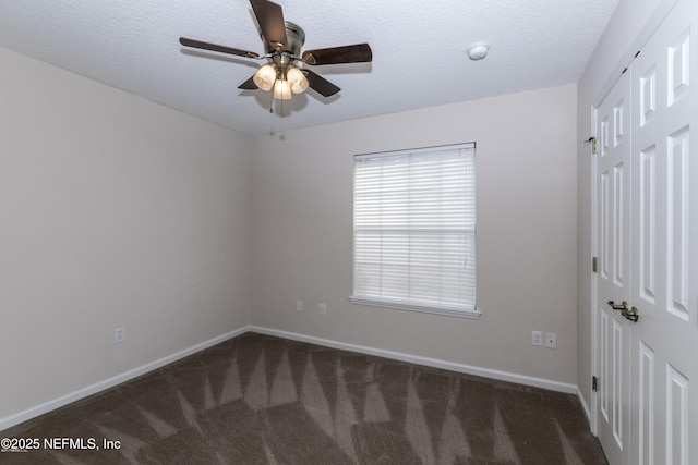 carpeted empty room featuring ceiling fan and a textured ceiling