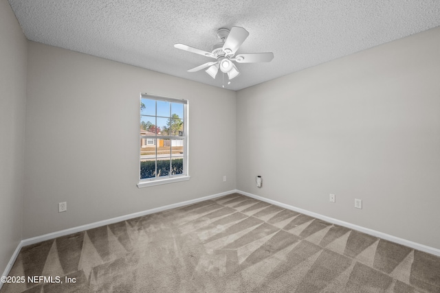 carpeted spare room featuring ceiling fan and a textured ceiling