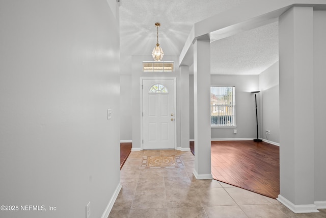 entryway featuring light tile patterned flooring and a textured ceiling