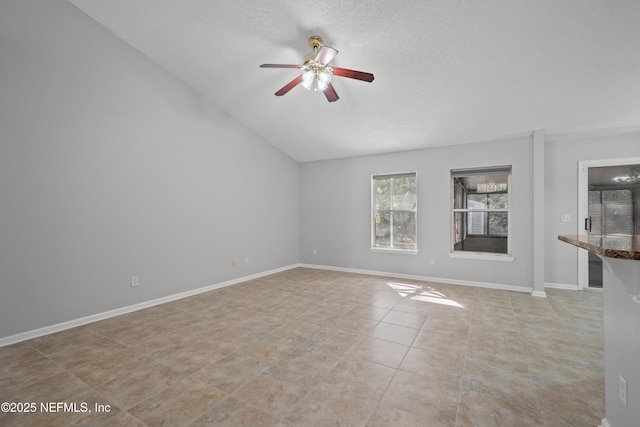 unfurnished living room with ceiling fan, lofted ceiling, a textured ceiling, and light tile patterned floors