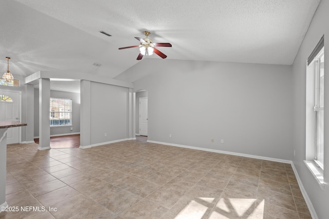 unfurnished living room with lofted ceiling, light tile patterned floors, a textured ceiling, and ceiling fan