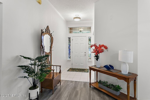 entryway featuring light wood-type flooring and a textured ceiling