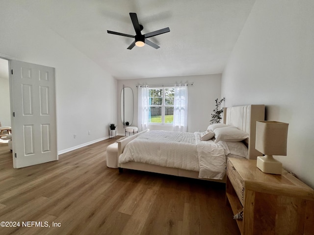 bedroom featuring wood-type flooring, ceiling fan, and vaulted ceiling