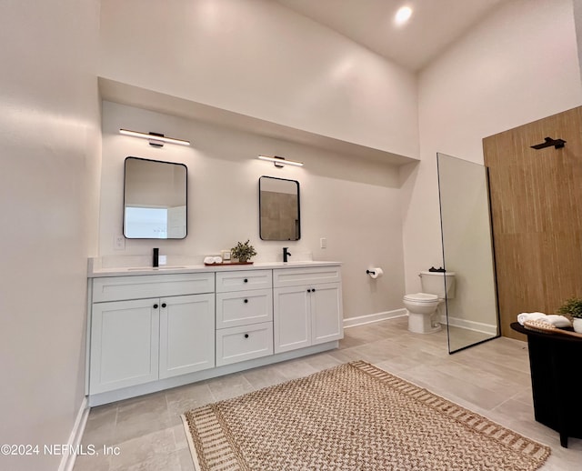 bathroom featuring a towering ceiling, vanity, and toilet