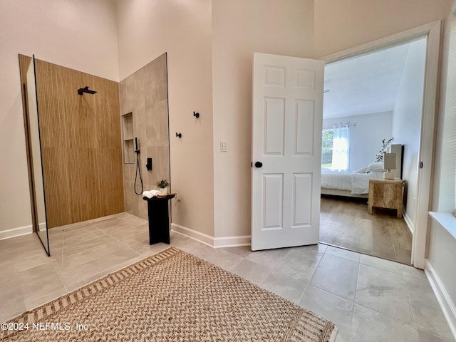 bathroom with a tile shower and tile patterned floors