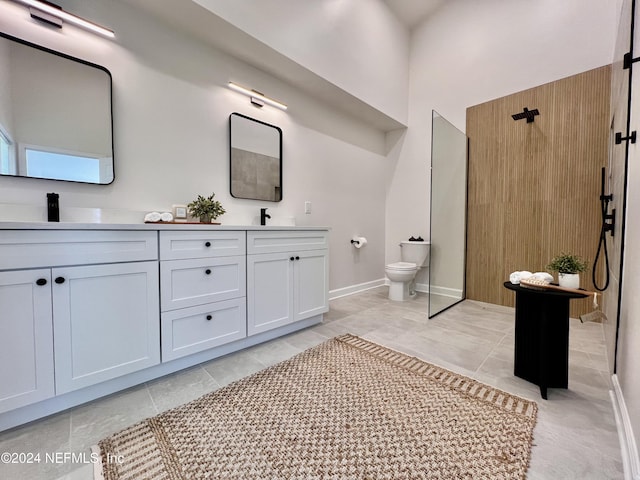 bathroom featuring tile patterned flooring, vanity, walk in shower, and toilet