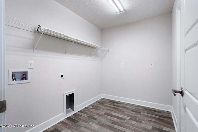 laundry room featuring electric dryer hookup, hookup for a washing machine, dark hardwood / wood-style floors, and a textured ceiling