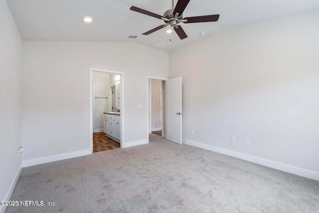 unfurnished bedroom with vaulted ceiling, carpet floors, ceiling fan, and ensuite bath