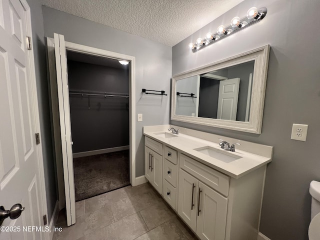 bathroom featuring vanity, a textured ceiling, and toilet