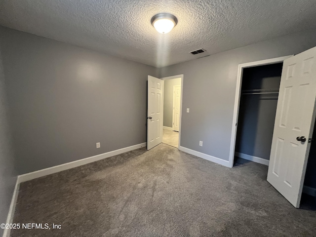 unfurnished bedroom featuring a closet, a textured ceiling, and dark colored carpet