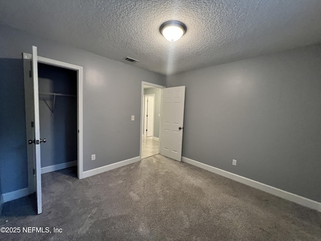 unfurnished bedroom featuring carpet flooring, a textured ceiling, and a closet