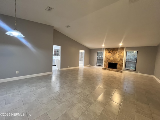 unfurnished living room with light tile patterned flooring, lofted ceiling, and a fireplace