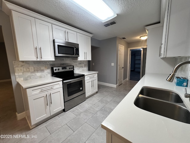 kitchen featuring white cabinetry, appliances with stainless steel finishes, sink, and tasteful backsplash